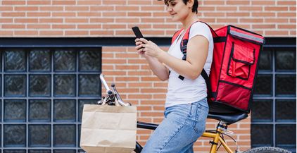 woman-with-red-backpack-holding-bag-of-food-in-cit-2022-02-16-22-28-23-utc