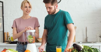 couple-of-vegans-preparing-vegetable-juice-with-ju-2021-09-03-05-16-59-utc