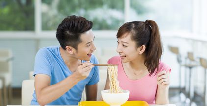 young-couple-having-noodles-in-restaurant-2022-03-24-16-34-33-utc