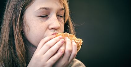 a-little-girl-with-freckles-eats-a-burger-2022-02-09-07-02-57-utc