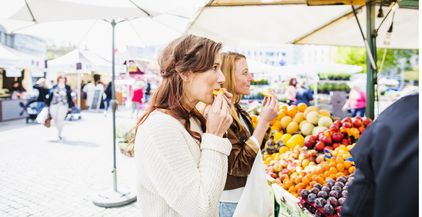 women-eating-fruit-while-shopping-at-market-2021-08-29-00-57-25-utc