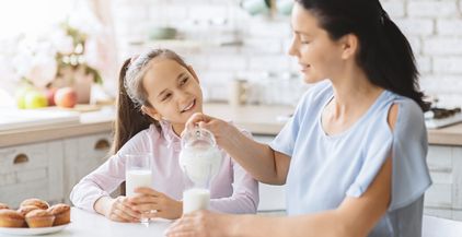 mother-and-daughter-drinking-milk-in-kitchen-toget-2021-08-26-16-33-38-utc