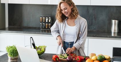 happy-young-woman-making-a-salad-at-the-kitchen-2022-02-02-04-51-14-utc