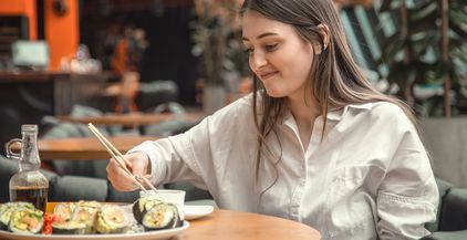 young-woman-eating-and-enjoying-fresh-sushi-2021-09-02-06-26-05-utc