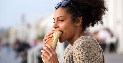 beautiful-young-woman-eating-sandwich-outdoors-2021-08-26-23-05-06-utc