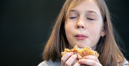 a-little-girl-with-freckles-eats-a-burger-2022-02-22-06-15-08-utc