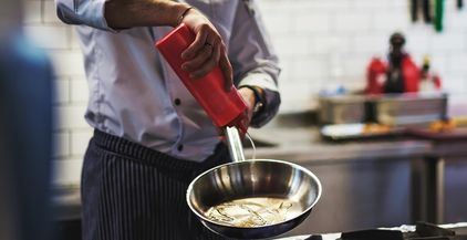 caucasian-chef-hand-pours-vegetable-oil-on-a-fryin-2021-08-26-15-50-36-utc
