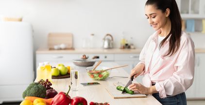 portrait-of-smiling-young-lady-cooking-fresh-salad-2021-09-03-15-22-59-utc