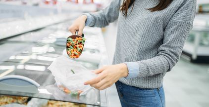 woman-picks-up-package-of-frozen-vegetables-2021-08-26-16-26-17-utc