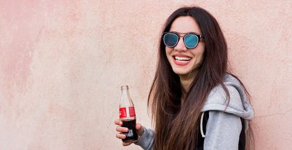 a-woman-with-sunglasses-holds-coca-cola-bottle-and-2021-09-04-03-02-49-utc
