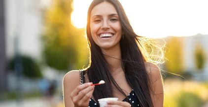 beautiful-young-woman-smiling-while-eating-an-ice-2022-02-01-22-38-52-utc