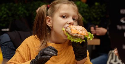 a-girl-eats-a-burger-with-black-gloves-2021-08-29-14-53-27-utc